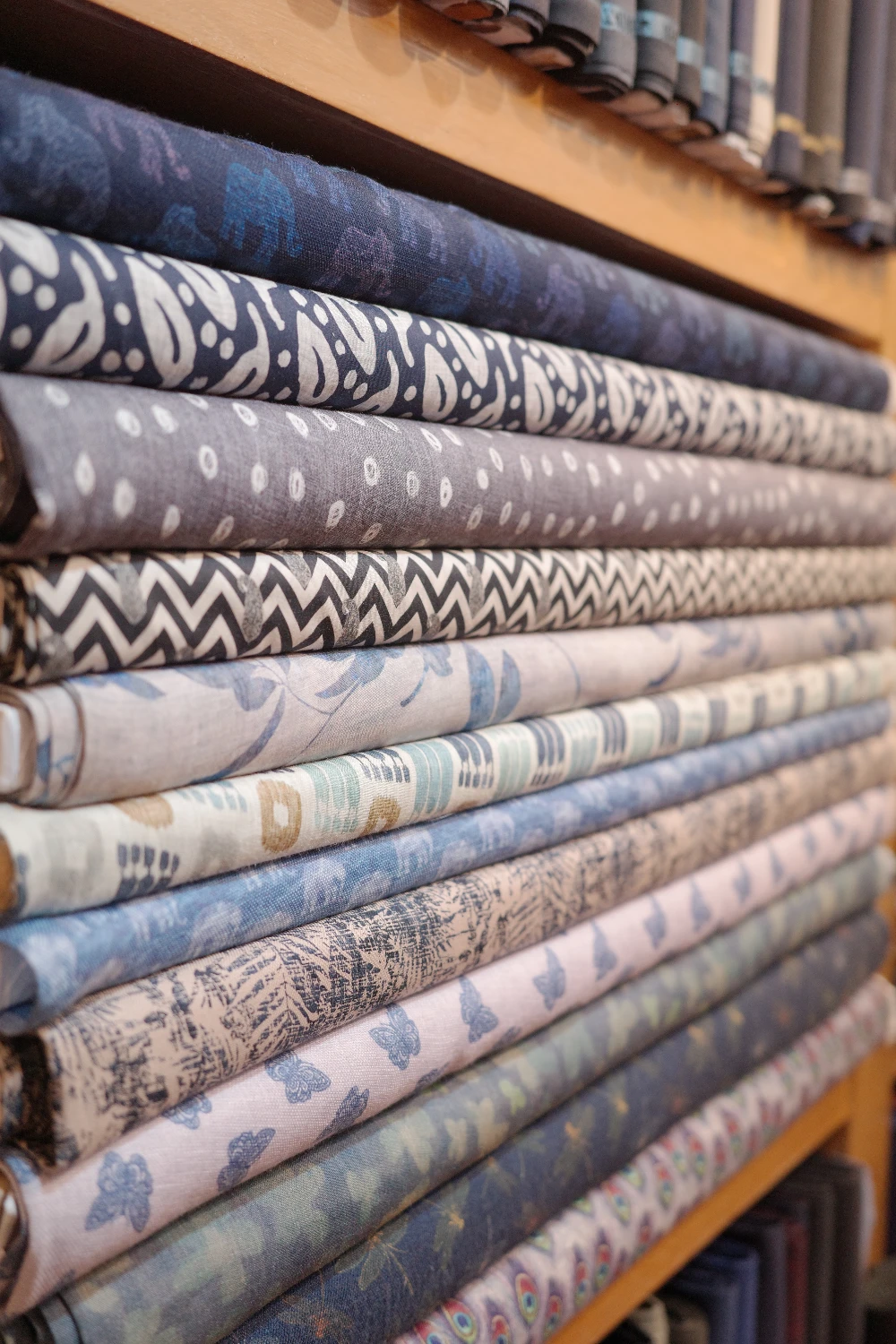 Premium wool, linen, and Thai silk fabric bolts at Om Fashion tailor in Bangkok